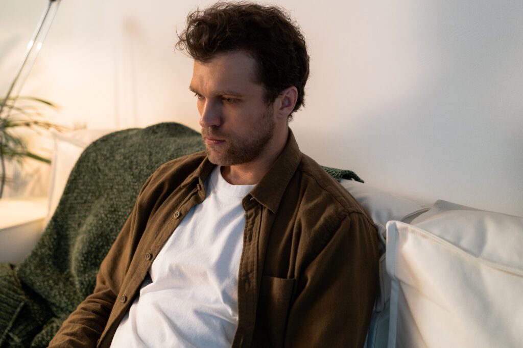 Self-conscious man seated alone and looking hesitant
