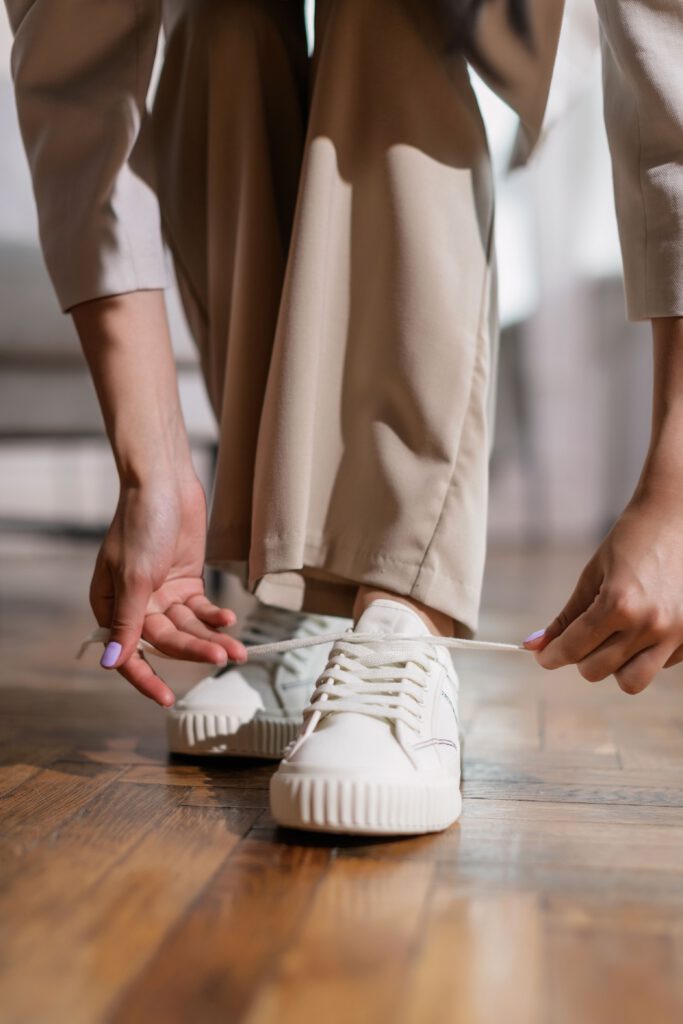 Person tying their shoes as a small first step toward movement